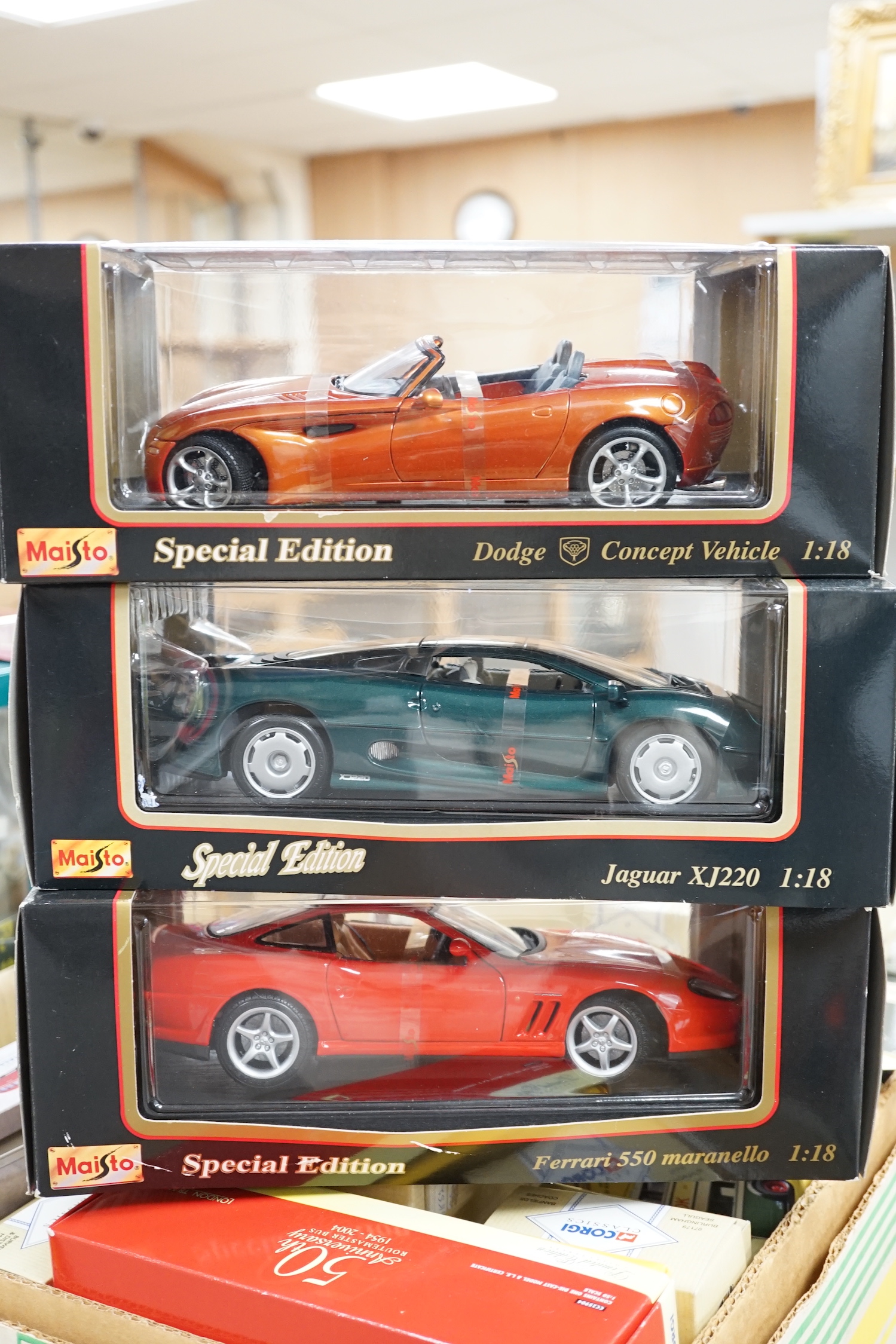Five boxed Maisto 1:18 model cars; Porsche Boxster, Ferrari 550 maranello, Jaguar XK8, Dodge Concept vehicle and a Jaguar XJ220